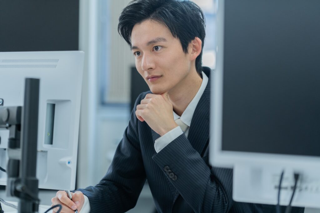 パソコンを見つめて考える男性